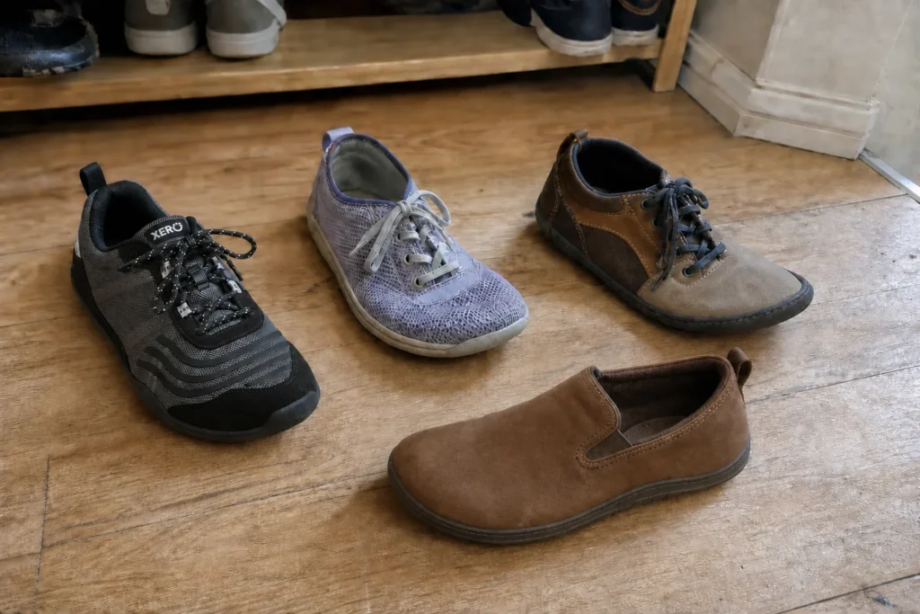 Xero Shoes 360 among four barefoot shoes on a hallway floor