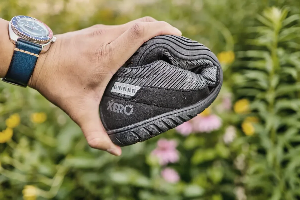 A real Xero Shoes 360 folded in one hand to show its flexible sole