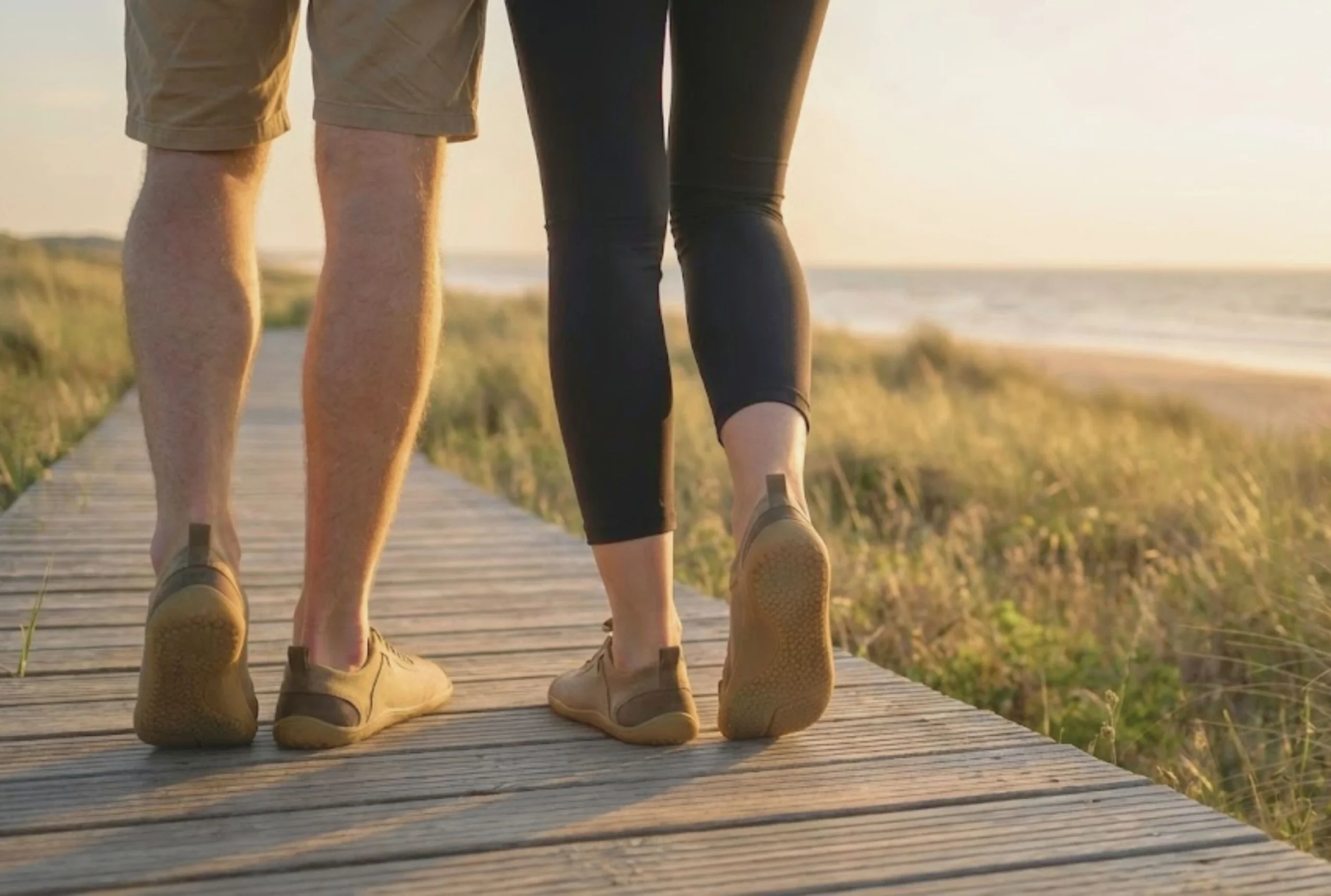 a couple walking on the beach wearing barefoot casual shoes