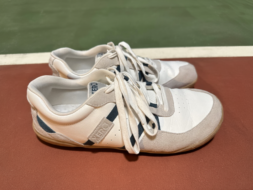 a pair of white xero shoes kelso on the pickleball court