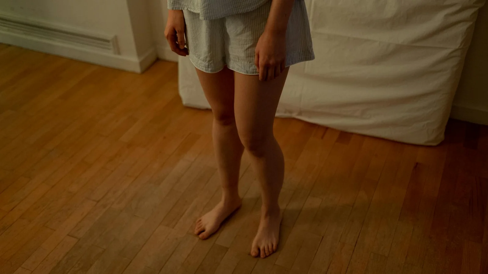 Tired bare feet on hardwood floor after long shift showing need for proper barefoot footwear