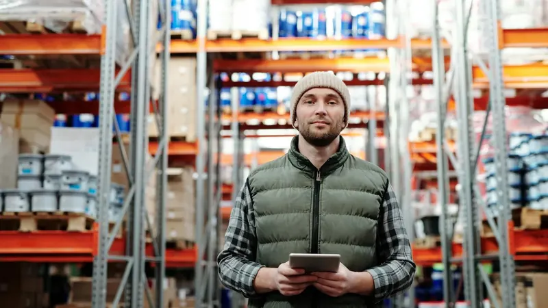 Warehouse worker standing on concrete floor during shift requiring durable barefoot work shoes