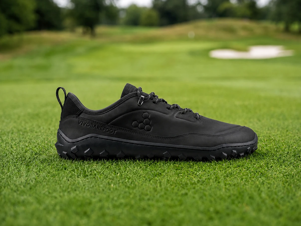 Vivobarefoot Tracker AT Low barefoot golf shoe side profile on green fairway turf showing zero-drop flat sole