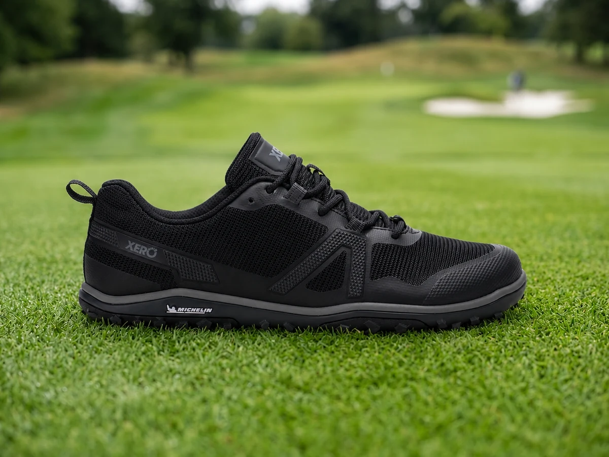 Xero Scrambler Low EV barefoot golf shoe side profile on green fairway turf showing zero-drop flat sole
