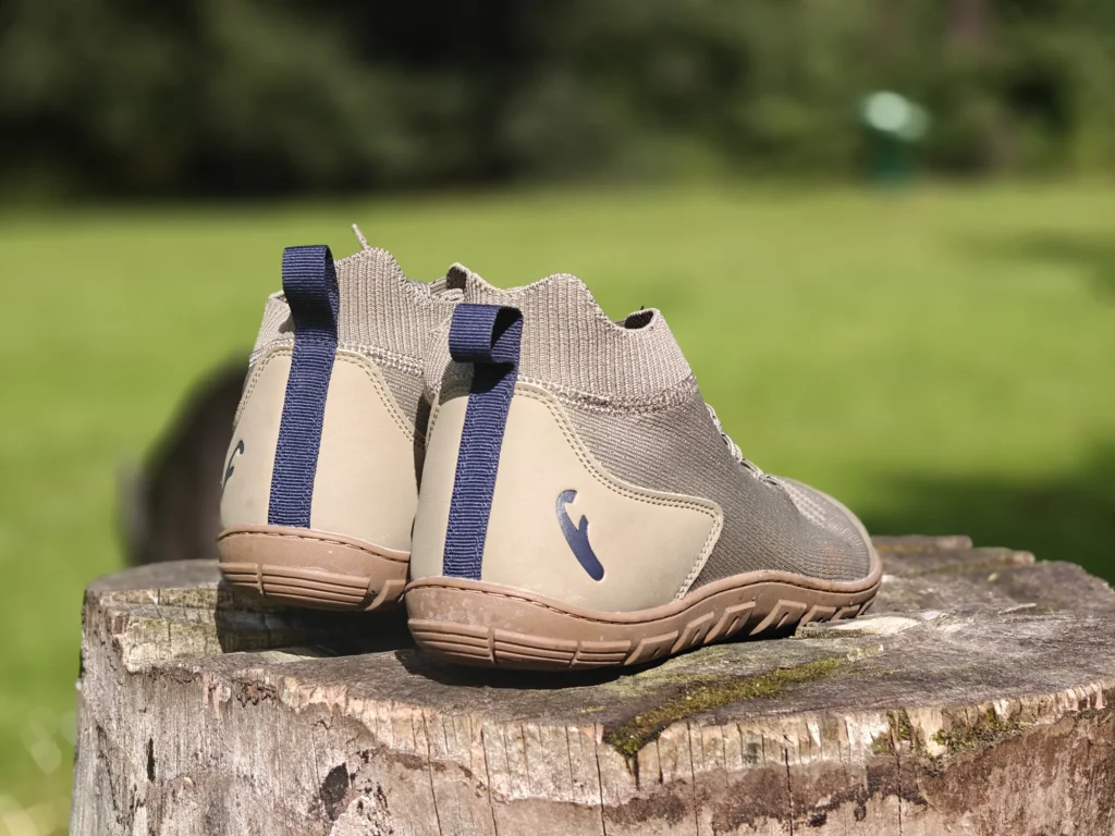 Rear three-quarter view of the Freet Danum boots on a tree stump, showing the heel counter and blue pull tabs.
