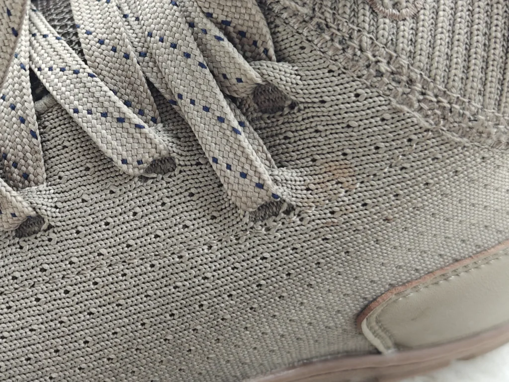 Macro view of the Freet Danum lower laces passing through openings formed directly in the knit upper.