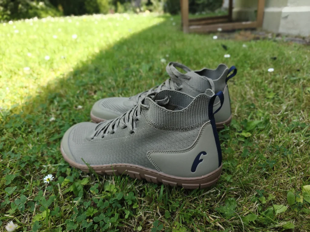 Pair of Freet Danum barefoot boots standing on a grass lawn in daylight.